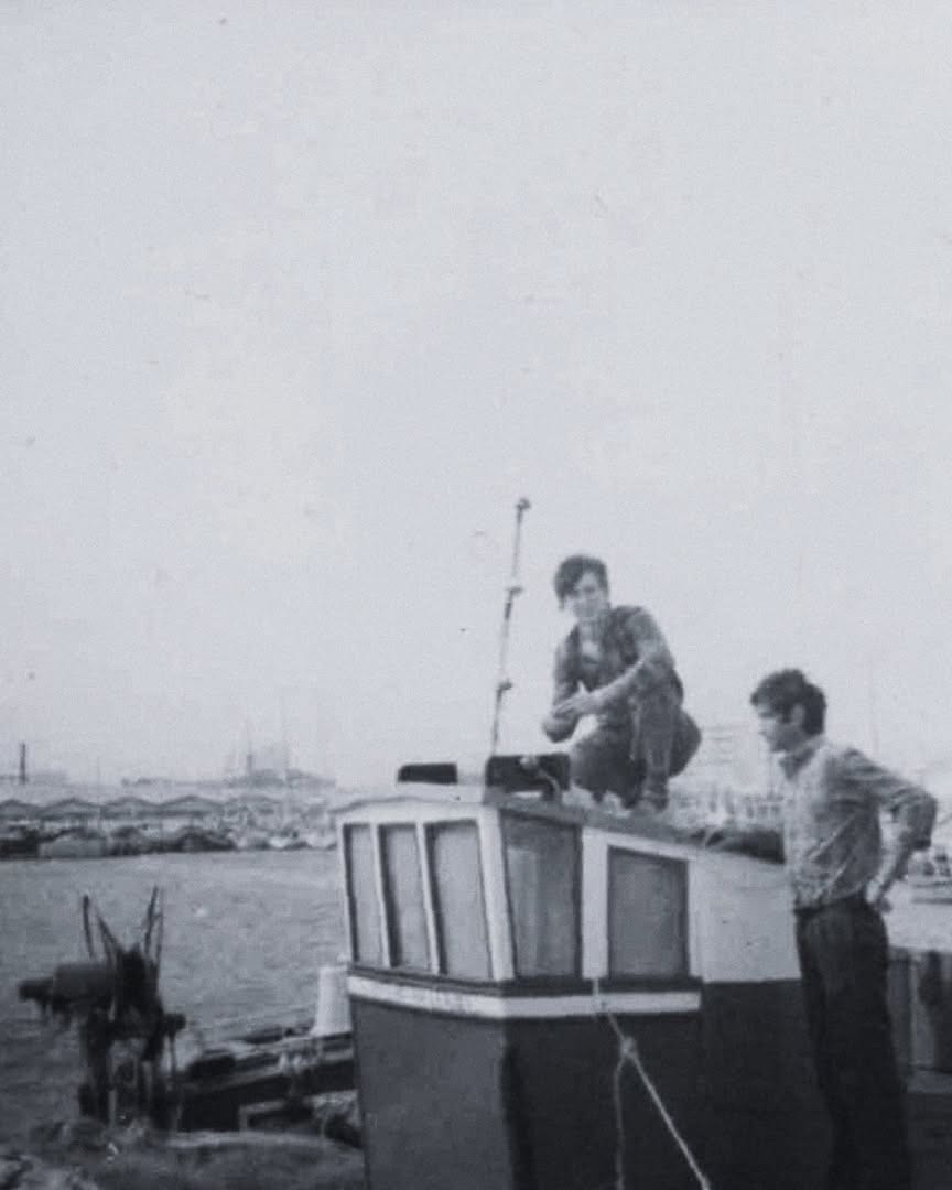 Fotografia antiga: pescadores num barco na ria